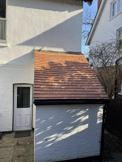 New clay tile pitched roof on side extension